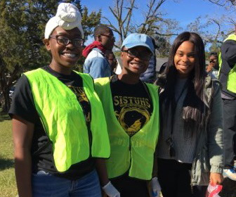 Volunteers helping to clean up a neighborhood smile for the camera with the hopes that the day stays cool